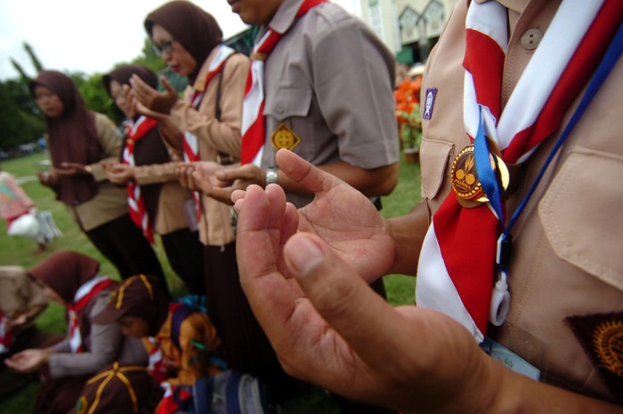 Sejumlah guru dan anggota pramuka melaksanakan doa bersama untuk korban susur sungai SMPN 1 Turi, Sleman di Alun-alun Tegal, Jawa Tengah, Sabtu (22/2/2020). Mereka mendoakan agar satu korban segera ditemukan dan sembilan korban yang meninggal memperoleh pengampunan Allah SWT. ANTARA FOTO/Oky Lukmansyah/aww.