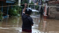 Warga memantau kondisi banjir.