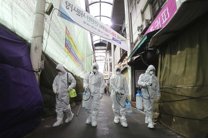 A member of the medical team takes a rest outside a hospital in Daegu, South Korea, Sunday, Feb. 23, 2020. South Korea's president has put his country on its highest alert for infectious diseases, saying Sunday that officials should take 