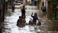 Anak-anak juga seperti sudah biasa dengan banjir. Mereka asyik bermain.