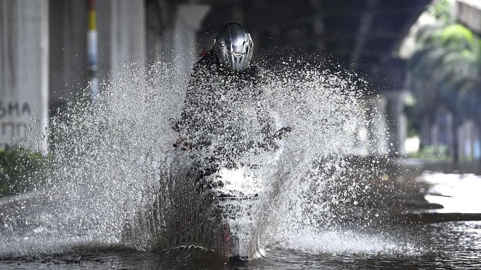 Pengendara sepeda motor mencoba melintasi banjir di Jalan Yos Sudarso, Kelapa Gading, Jakarta Utara, Minggu (23/2/2020). Hujan deras sejak Minggu 23 Februari dini hari membuat sejumlah daerah di Ibu Kota tergenang banjir. ANTARA FOTO/Sigid Kurniawan/wsj.
