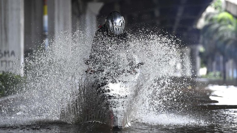 Banjir Jakarta Pengendara sepeda motor mencoba melintasi banjir di Jalan Yos Sudarso, Kelapa Gading, Jakarta Utara, Minggu (23/2/2020). Hujan deras sejak Minggu 23 Februari dini hari membuat sejumlah daerah di Ibu Kota tergenang banjir. ANTARA FOTO/Sigid Kurniawan/wsj.