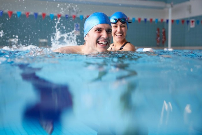 1167733537 Female Swimming Teacher Giving Man One To One Lesson In Pool