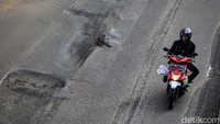 Jalan tersebut tampak rusak dan berlubang.