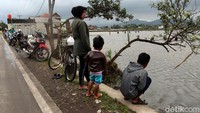 Tak sedikit warga maupun pengendara yang melintas di kawasan itu berhenti sejenak untuk melihat aktivitas para penjala ikan di area persawahan yang kebanjiran tersebut.