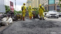 Sejumlah bahan dan alat digunakan untuk membantu petugas memperbaiki jalan berlubang tersebut.