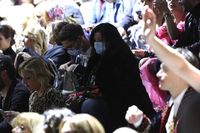 Tamu fashion show Dolce & Gabbana di Milan Fashion Week memakai masker menyusul mewabahnya virus corona di Italia.