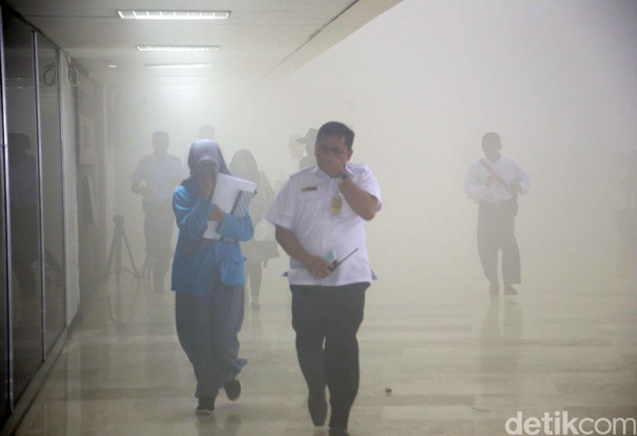 Asap mengepul di Gedung Nusantara III DPR, Senin (24/2/2020). Para penghuni gedung wakil rakyat berhamburan.
