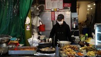 Seorang pedagang di kawasan Seoul tampak memasak sejumlah makanan ringan yang akan dijajakan kepada para pengunjung di salah satu pasar tradisional yang berada di Ibu Kota Korea Selatan tersebut. Getty Images/Chung Sung-Jun.