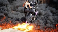 Christina kerap memasang foto yang menantang. Salah satunya wheelie sembari melintasi kobaran api. Foto: Pool Instagram