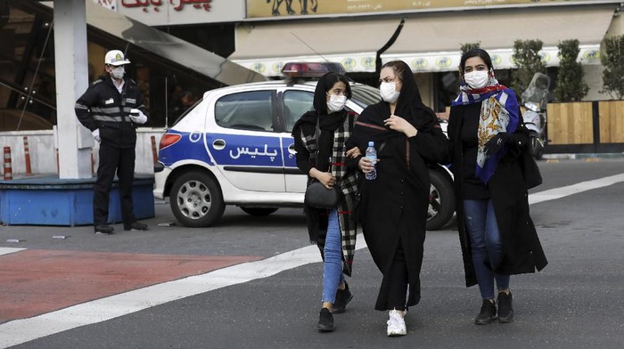 A policeman and pedestrians wear masks to help guard against the Coronavirus, in downtown Tehran, Iran, Sunday, Feb. 23, 2020. On Sunday, Irans health ministry raised the death toll from the new virus to 8 people in the country, amid concerns that clusters there, as well as in Italy and South Korea, could signal a serious new stage in its global spread. (AP Photo/Ebrahim Noroozi)