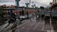 Meski air masih menggenangi jalan, sejumlah pengendara memilih untuk melintasi jalan yang tergenang tersebut untuk beraktivitas.