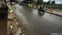 Aktivitas kendaraan berjalan normal pasca banjir yang mengakibatkan pagar jembatan rusak.