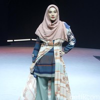 Dhini Aminarti membuka fashion show persembahan Wardah di MUFFEST 2020 dengan berjalan di catwalk sebagai model busana muslimah karya brand KAMI. Dhini tampil dengan lipstik bold berwarna merah saat memeragakan busana KAMI yang dihiasi bunga melati. Foto: Mohammad Abduh/Detikcom