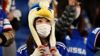Seorang suporter mengenakan masker saat menonton pertandingan sepakbola di Stadion Nissan, Yokohama, Kanagawa, Jepang, pada Rabu (19/2) lalu. Matt Roberts/Getty Images.