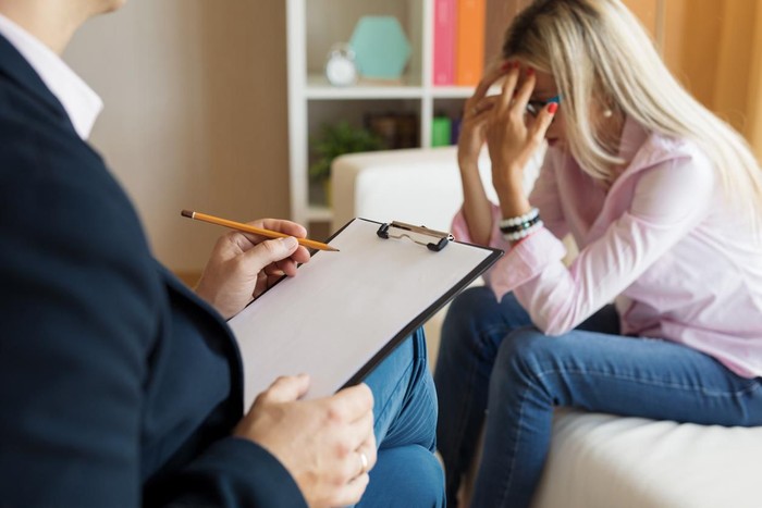Young desperate female visiting psychologist