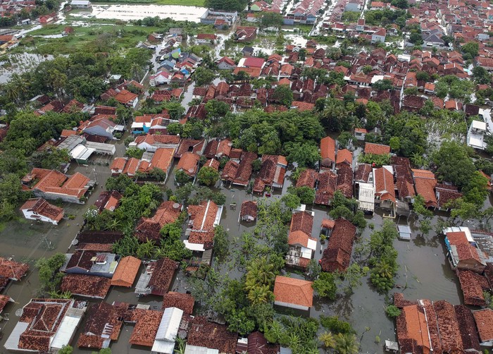 Polisi membantu pengendara mendorong motornya yang mogok akibat banjir di Jalur Pantura Pekalongan, Jawa Tengah, Senin (24/2/2020). Hujan yang terjadi sejak Minggu (23/2) sore membuat sejumlah ruas jalan Pantura Pekalongan banjir yang menyebabkan kendaran berjalan tersendat sepanjang sekitar 500 meter. ANTARA FOTO/Harviyan Perdana Putra/aww.