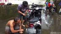 Warga pun saling bantu memperbaiki motor yang terendam banjir tersebut.