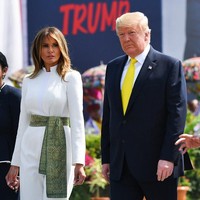 Melania Trump tampak memakai jumpsuit putih formal berpotongan maskulin yang terinspirasi dari kostum tradisional pria India. Kerah dan siluet atasannya seperti jas tutup yang umum di Indonesia. Celana berpotongan flare menjaga penampilan ibu satu anak itu tetap elegan. (Foto: Mandel NGAN / AFP)