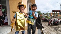 Mengenakan kostum dari sampah plastik, anak-anak tetap semringah.
