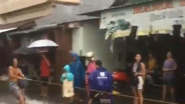 Pria berselancar di jalanan yang banjir