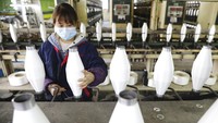 Wabah virus corona yang melanda  berbagai negara di dunia membuat warga mengenakan masker pelindung pernapasan guna mengantisipasi penyebaran virus corona saat bekerja maupun beraktivitas sehari-hari. Seperti halnya pekerja di salah satu pabrik tenun yang berada di Hangzhou, Provinsi Zhejiang, China. Chinatopix via AP Photo.