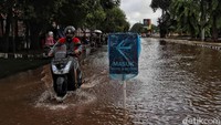 Para pengendara motor pun tampak berhati-hati saat melintasi jalan yang masih tergenang tersebut.