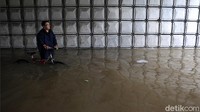 Seorang warga menerobos banjir menggunakan sepeda.