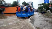 Oleh karena itu, alat berat hingga truk Satpol PP digunakan untuk membantu warga melintasi jalan yang terendam banjir.