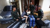 Prajurit TNI menyusuri perumahan yang terendam banjir untuk mengevakuasi warga ke tempat aman.