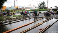 Sejumlah pengendara motor tampak melintasi rel kereta api yang berada di dekat Stasiun Pasar Senen, Jakarta.