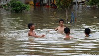 Sejumlah anak berenang dan bermain air di saat banjir merendam kawasan Periuk, Tangerang, Selasa (25/2/2020).