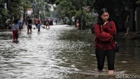 Ada pula warga yang berjalan kaki menerobos banjir untuk dapat beraktivitas.
