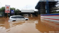 Sebuah mobil mogok akibat menerobos banjir di kolong Tol JORR Kalimalang.
