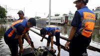 Petugas pun langsung melakukan pemeriksaan dan memperbaiki wesel yang terendam banjir tersebut.