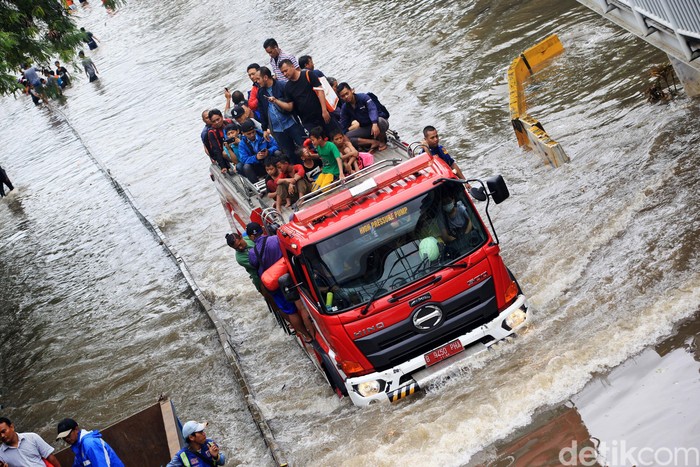 Petugas mengevakuasi warga yang melintasi banjir di Jalan Panjang di Kedoya Green Garden, Jakarta Barat, menggunakan Mobil pemadam kebakaran. Banjir memutus Jalan yang menghubungkan daerah Kebon Jeruk Dan Daan Mogot ini.