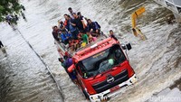 Warga yang akan melintas diangkut menggunakan mobil pemadam kebakaran.