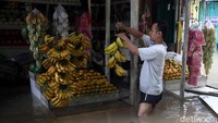 Agar tetap mendapat pemasukan sejumlah pedagang memilih tetap buka dan berjualan meski di tengah banjir.