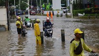 Para pemotor terpaksa menerobos banjir dengan memanfaatkan trotoar yang tinggi di kawasan Kemang.