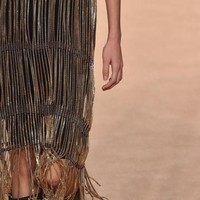 Koleksi Salvatore Ferragamo turut diwarnai busana-busana dengan fringe. Seperti dress penuh fringe yang ditengaki kepingan emas ini. (Foto: Getty Images)