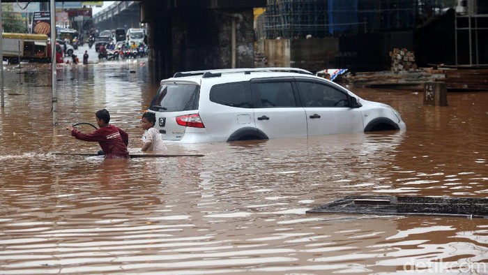 Mobil mogok ditengah banjir di Bawah Kolong Tol JORR Kalimalang, Kota Bekasi, Jawa Barat, Selasa (25/2/2020). Jalan Drainase yang buruk dan hujan deras yang terus mengguyur wilayah Kota Bekasi dan sekitarnya, mengakibatkan banjir dan menyulitkan akses warga bekasi menuju Jakarta maupun sebaliknya .