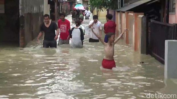 Warga menerobos banjir yang melanda permukimannya di Subang. 