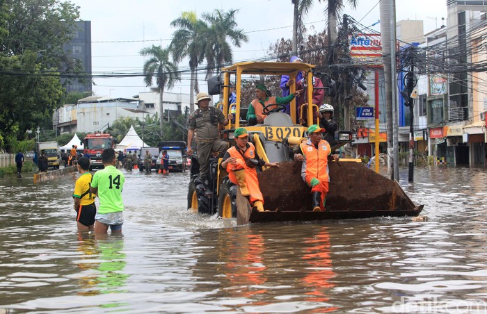 Banjir yang rendam jalan di Kedoya membuat warga kesulitan untuk beraktivitas. Alat berat hingga truk Satpol PP pun digunakan untuk bantu warga menerjang banjir