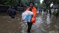 Sejumlah warga tampak keluar dari rumah mereka yang terendam banjir dan beraktivitas di luar rumah.