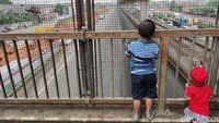 Dua orang bocah terlihat mengintip dari JPO di kawasan Tol Japek.
