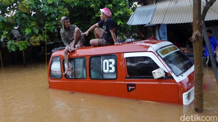 Banjir di Rawadas Pondok Kopi Sejumlah warga melintasi banjir di RT 2 RW 3 Rawadas, Pondok Kopi, Jakarta Timur, Selasa (25/2/2020). Banjir yang melanda kawasan ini mencapai 90 meter.