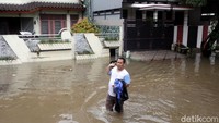 Terlihat hanya satu atau dua orang yang melintas di kawasan perumahan yang terendam banjir di Bekasi.