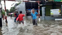 Anak-anak tampak asyik bermain dengan temannya ditengah genangan air yang seperti kolam renang pribadi miliknya.