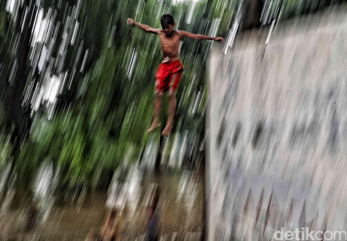 Aksi Berbahaya Anak-anak Saat Banjir Sejumlah anak bermain di kawasan taman yang dekat dengan aliran sungai terdampak banjir di kawasan Semper Barat, Jalan Sungai Brantas, Selasa (25/2). Tindakan tersebut berbahaya dilakukan karena rawan akan kecelakaan karena banyak batu dan pipa besi.
