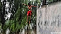 Sejumlah anak bermain di sungai yang meluap di kawasan Semper Barat, Jakarta Utara, Selasa (25/2/2020).